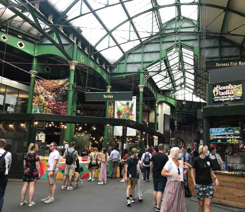 Shoppers and tourists enjoying showing Victorian ironwork structure.