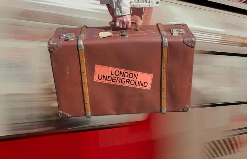 London Underground Vintage brown leather suitcase with category travel label on a speeding tube train.