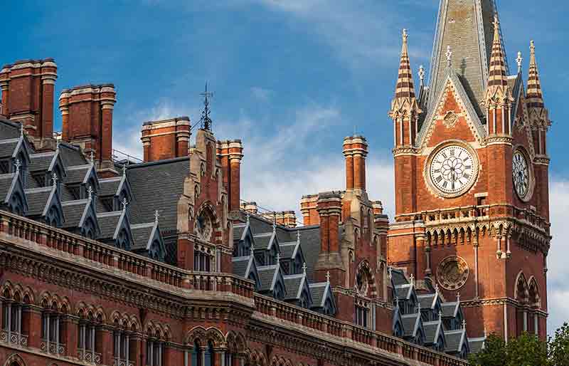 Exterior and clock tower in Victorian Gothic style.